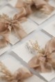 Minimalistyczne zaproszenie z gałązką suszonej trawy, styl boho